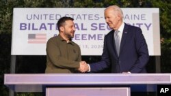 El presidente Joe Biden y el presidente ucraniano Volodymyr Zelenskyy se dan la mano después de firmar un acuerdo de seguridad al margen de la cumbre del G7, el 13 de junio de 2024, en Savelletri, Italia.
