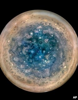 This image made available by NASA on May 25, 2017, and made from data captured by the Juno spacecraft shows Jupiter's south pole. The oval features are cyclones, up to 600 miles (1,000 kilometers) in diameter.