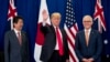 President Donald Trump, accompanied by Japanese Prime Minister Shinzo Abe, left, and Australian Prime Minister Malcolm Turnbull, right, waves to reporters at a meeting during the ASEAN Summit at the Sofitel Philippine Plaza, Monday, Nov. 13, 2017, in Mani