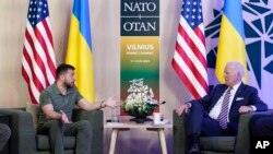El presidente de Ucrania, Volodymyr Zelenskyy, a la izquierda, y su homólogo de Estados Unidos, Joe Biden, conversan durante un encuentro en los márgenes de la cumbre de la OTAN en Vilna, el 12 de julio de 2023.