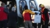 El presidente de Chile, Sebastián Piñera, observa mientras los trabajadores llevan el primer lote de la vacuna Pfizer-BioNTech COVID-19 a un helicóptero. Chile, jueves 24 de diciembre de 2020.