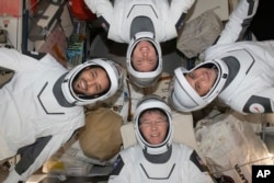 En esta fotografía de mayo de 2023 proporcionada por la NASA, en el sentido de las agujas del reloj desde abajo, el astronauta de la NASA Stephen Bowen, el astronauta de los Emiratos Árabes Unidos Sultan al-Neyadi, el astronauta de la NASA Warren (Woody) Hoburg y el cosmonauta de Roscosmos Andrei Fedyaev posan para un retrato con sus trajes presurizados a bordo de la Estación Espacial International.