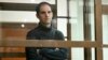 FILE - Wall Street Journal reporter Evan Gershkovich stands in a glass cage in a courtroom at the Moscow City Court, in Moscow, Russia, on Dec. 14, 2023. 