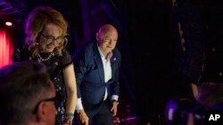 El senador Mark Kelly con su esposa, la exrepresentante Gabrielle Giffords, saludan a simpatizantes en Tucson, Arizona, el 8 de noviembre de 2022.