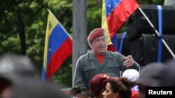 Un recorte de cartón de tamaño real del fallecido presidente venezolano Hugo Chávez se encuentra en medio de la multitud durante una manifestación en apoyo de Nicolás Maduro y para conmemorar el 1 de Mayo en Caracas, Venezuela. REUTERS