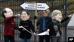 Activistas protestan sobre el rol de los líderes mundiales y los representan (presidente francés Hollande, primer ministro japonés Shinzo Abe, presidente Obama y Angela Merkel) en encontrar una manera para enfrentar el calentamiento global frente de las instalaciones donde se desarrolló la conferencia de la ONU, en Varsovia.