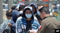 ARCHIVO - Oficiales de la Patrulla Fronteriza devuelven a un grupo de migrantes en el puesto fronterizo de Nuevo Laredo.