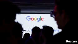 Siluetas de personas frente al logotipo de Google durante la inauguración de un nuevo centro en Francia dedicado al sector de la inteligencia artificial (IA), en la sede de Google Francia en París, el 15 de febrero de 2024.
