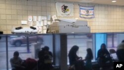 ARCHIVO - Inmigrantes de Venezuela en la estación del Distrito 16 del Departamento de Policía de Chicago el lunes 1 de mayo de 2023. (Foto AP/Charles Rex Arbogast, archivo)
