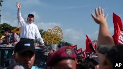 El presidente de Nicaragua, Daniel Ortega, y su esposa, la vicepresidenta Rosario Murillo, llegan a la plaza Juan Pablo II para celebrar el 39 aniversario de la revolución sandinista, en Managua, Nicaragua. (Foto AP/Cristóbal Venegas)
