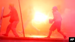 Manifestantes llamados "desactivadores" y activistas de "primera línea" se enfrentan con policías durante una protesta contra el gobierno, el sábado 28 de enero de 2023, en Lima. 