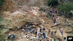 Rescatistas, residentes y voluntarios buscan víctimas después de un deslizamiento de tierra causado por fuertes lluvias en la ciudad costera de Guarujá, Brasil, el miércoles 4 de marzo de 2020.