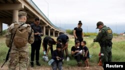 Un agente de Aduanas y Protección Fronteriza recopila información biográfica de un grupo de migrantes venezolanos antes de detenerlos cerca de la ciudad fronteriza sur de Eagle Pass, Texas, EE.UU. 25 de abril de 2022.