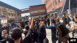 Esta imagen de un video de UGC disponible el 15 de octubre de 2022 muestra a estudiantes iraníes cantando "Libertad" mientras se manifiestan en la Universidad de Ciencia y Cultura de Teherán.