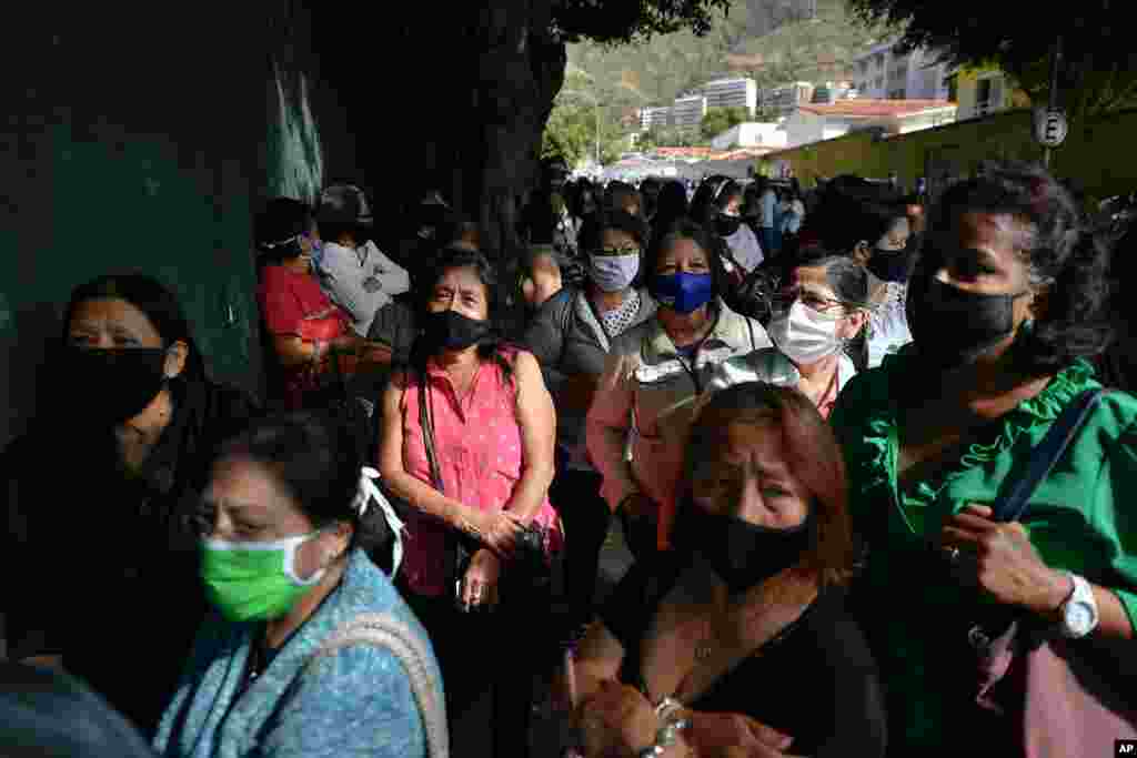 Los ecuatorianos que viven en Venezuela, con máscaras protectoras para protegerse de la propagación del nuevo coronavirus, esperan ingresar a un colegio electoral en Caracas, Venezuela, el domingo 7 de febrero de 2021.