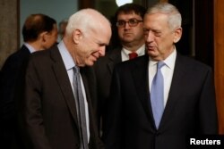 El senador John McCain (izq.), jefe de la Comisión de Servicios Armados del Senado recibe al general en retiro James Mattis para la audiencia de confirmación de Mattis como Secretario de Defensa.