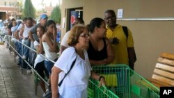 La gente en Puerto Rico hace fila en los supermercados en busca de alimentos no perecederos.