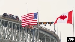 Las banderas de Estados Unidos y Canadá ondean en el lado estadounidense del río St. Clair, cerca del cruce fronterizo del puente Bluewater entre Sarnia, Ontario y Port Huron, Michigan, el 29 de enero de 2025.