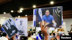 CIDH solicita a Corte Interamericana, ordene al estado nicaragüense respetar la integridad de líderes opositores detenidos, para los que existen medidas cautelares que han sido violadas. Persona levanta foto de periodista Miguel Mora (Foto archivo)
