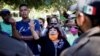 Migrantes hablan con miembros del Instituto Nacional de Migración (INM) de México en un campamento improvisado cerca de la frontera con Estados Unidos, en Ciudad Acuña, México, el 23 de septiembre de 2021.