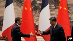 ARCHIVO - El presidente francés Emmanuel Macron, izquierda, estrecha su mano con su homólogo chino Xi Jinping tras reunirse con los medios en el Gran Salón del Pueblo, en Beijing, el jueves 6 de abril de 2023.