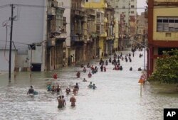 Residentes de La Habana se mueven entre las inundadas calles de la ciudad tras el paso del huracán Irma. Sept. 10, 2017.