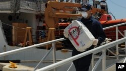 Un efectivo de la Guardia Costera de EE.UU. desembarca cocaína decomisada recientemente.