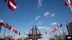位于布鲁塞尔的北约总部外的北约标志及成员国国旗。