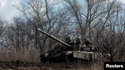 Los miembros del servicio ucraniano viajan en la cima de un tanque fuera de la ciudad de primera línea de Bájamut, en medio del ataque de Rusia contra Ucrania, en la región de Donetsk, Ucrania, 4 de marzo de 2023. Reuters/Oleksandr Ratushniak