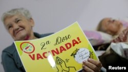 Una anciana brasileña muestra un letrero de Vacunada! tras recibir la segunda dosis de la vacuna china CoronaVac contra COVID-19 en Sao Paulo, Brasil, el 26 de febrero de 2021.