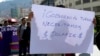 ARCHIVO - Un comerciante sostiene un cartel con un mensaje que dice en español: "¡Gobierno actual, necesitamos dólares!". Durante una protesta en La Paz, Bolivia, el viernes 17 de mayo de 2024.