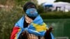 A woman wrapped in the national flag of the Democratic Republic of Congo prays at Gemelli hospital, where Pope Francis is hospitalized with pneumonia, in Rome on March 1, 2025.