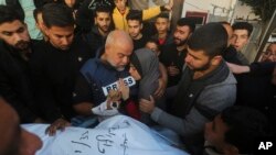 El periodista de Al Jazeera, Wael Dahdouh, toma la mano de su hijo Hamza, quien también trabajaba para Al Jazeera y murió en un ataque aéreo israelí en Rafah, Franja de Gaza, el domingo 7 de enero de 2024.