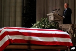 Former President George W. Bush speaks in front of the flag-draped casket of his father, former President George H.W. Bush, at the State Funeral at the National Cathedral, Dec. 5, 2018, in Washington.