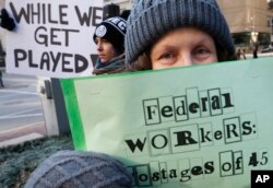 Esther Anastasia, una mujer en Boston, Massachusetts, sostiene un cartel que dice "Trabajadores Federales rehenes de 45" en referencia al presidente Trump, durante una protesta el viernes 11 de enero de 2019. Los trabajadores protestaron junto con el senador demócrata Ed Markey y otros partidarios para instar al presidente Trump a reabrir el gobierno.