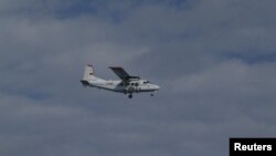 An airplane belonging to China's state oceanic administration flies past about 15 km (9 miles) south of one of the disputed islets in this handout released by 11th Regional Coast Guard Headquarters-Japan Coast Guard, December 13, 2012.