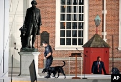 FILE - Law enforcement sweep the area in front of Independence Hall with the statue of President George Washington at left, before the arrival of Pope Francis, Sept. 26, 2015.