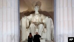 El presidente electo Donald Trump y su esposa, Melania Trump, saludan el monumento del Lincoln Memorial, al llegar la noche anterior a su posesión como presidente de EE.UU., al "Make America Great Again Welcome Concert".