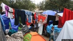 Un niño camina entre la ropa puesta a secar después de una intensa lluvia en el campamento de carpas de Reynosa, México. Foto Dylan Baddour/VOA.