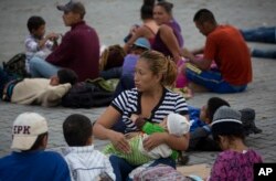 Una migrante hondureña amamanta a su hija antes de comenzar a caminar nuevamente como parte de una caravana de cientos de migrantes hondureños que se dirigen a Estados Unidos. Esquipulas, Guatemala. Martes 16 de octubre de 2018.