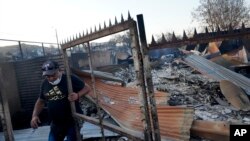 Claudio Zamora se encuentra sobre lo que queda de su casa quemada después de que un incendio forestal alcanzara el barrio Villa Independencia en Viña del Mar, Chile, el sábado 3 de febrero de 2024.