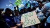 Manifestantes sostienen un cartel con un mensaje contrario al Decreto de Necesidad y Urgencia, con el que el gobierno busca desregular la economía de Argentina, durante un paro nacional, en Buenos Aires, el 24 de enero de 2024.