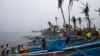 FILE - Homeless typhoon victims gather near their new fishing boats given by a religious organization along a coastal village devastated by super Typhoon Haiyan in Tacloban city, central Philippines.