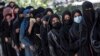 ARCHIVO - Estudiantes afganas hacen cola después de llegar para los exámenes de ingreso a la Universidad de Kabul, en Kabul, el 13 de octubre de 2022.