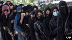 ARCHIVO - Estudiantes afganas hacen cola después de llegar para los exámenes de ingreso a la Universidad de Kabul, en Kabul, el 13 de octubre de 2022.