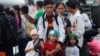 A father and his children who survived the massive Typhoon Haiyan, wait for an evacuation flight on the tarmac of the airport in Tacloban, Philippines, Nov. 21, 2013.