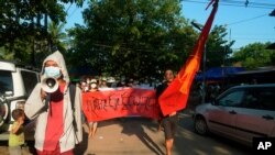 Manifestantes marchan para protestar contra el golpe militar de febrero en Rangún, Myanmar, el domingo 11 de abril de 2021. La pancarta dice: "Absolutamente no dictadura".