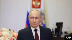 En esta fotografía de grupo distribuida por la agencia estatal rusa Sputnik, el presidente Vladimir Putin felicita a las mujeres rusas desde su residencia en Moscú, el 8 de marzo de 2024.