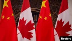 资料照片：在加拿大总理特鲁多和中国国家主席习近平2017年12月5日在北京钓鱼台国宾馆举行会晤前树立起的两国国旗。（路透社照片）