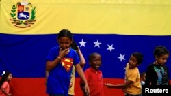 Niños juegan frente a la bandera de Venezuela en Caracas, Venezuela. Setiembre 7, 2019. Foto: REUTERS.